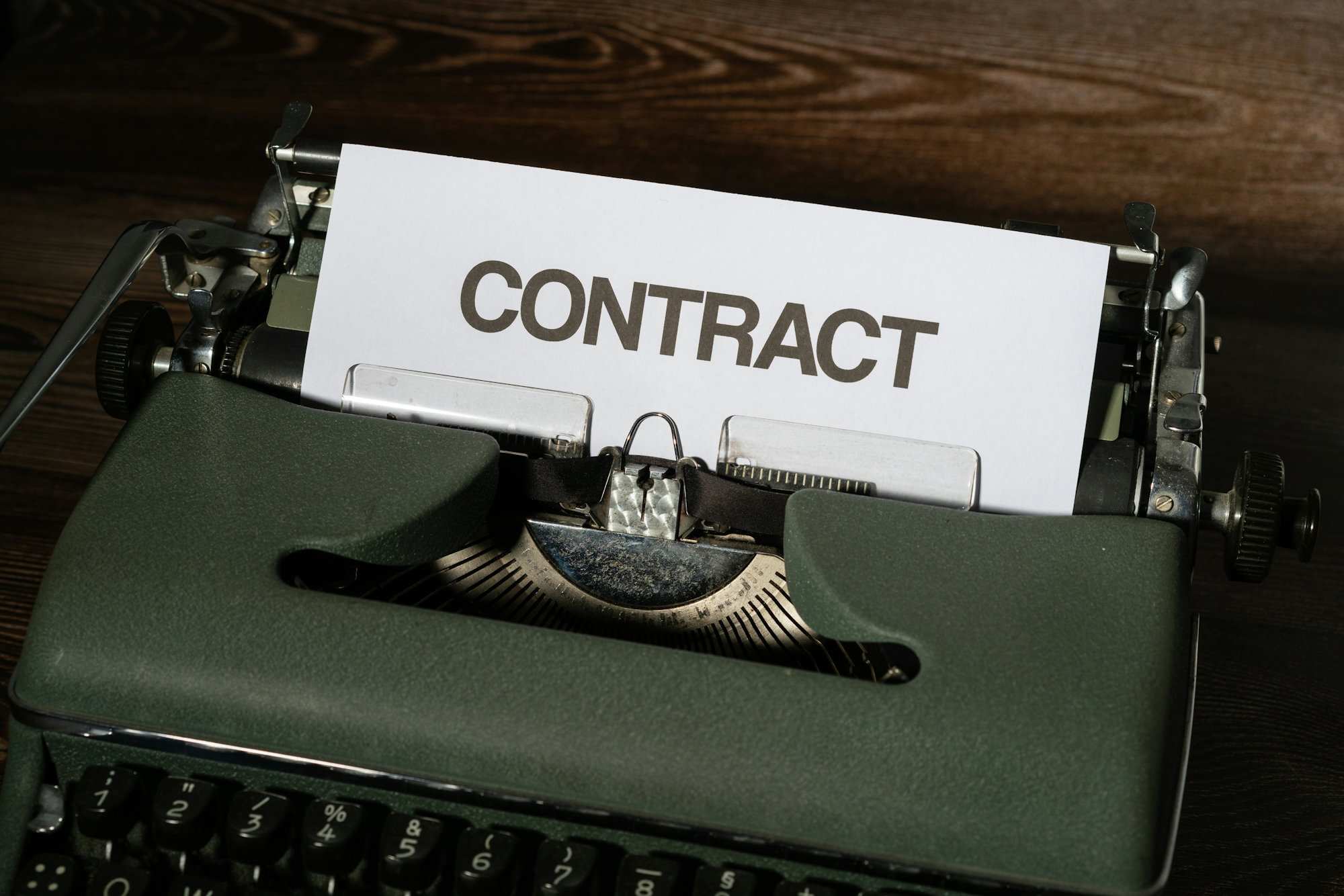 a-close-up-of-a-typewriter-with-a-sign-that-reads-contact.jpg a close up of a typewriter with a sign that reads contact