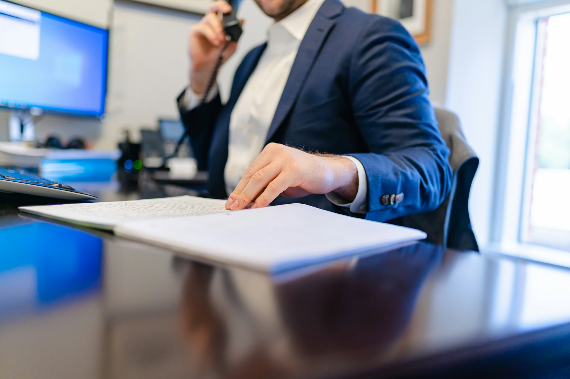 a-man-sitting-at-a-desk-writing-on-a-piece-of-paper.jpg a man sitting at a desk writing on a piece of paper